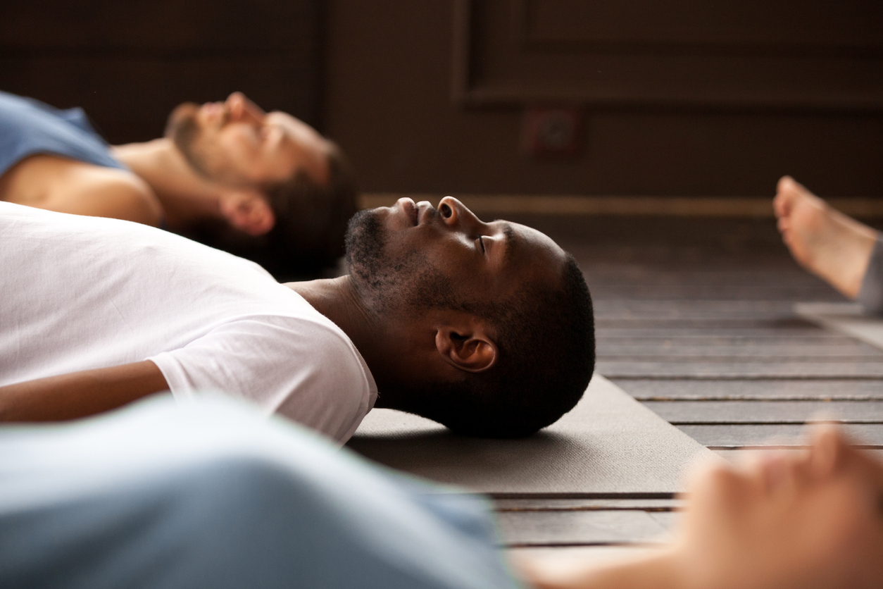 Group of sporty people in Savasana exercise