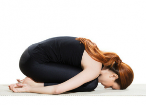 women in black outfit practicing yoga on the floor