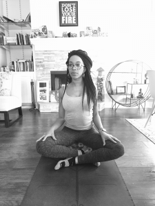 black and white image of women crossed leg while on yoga mat