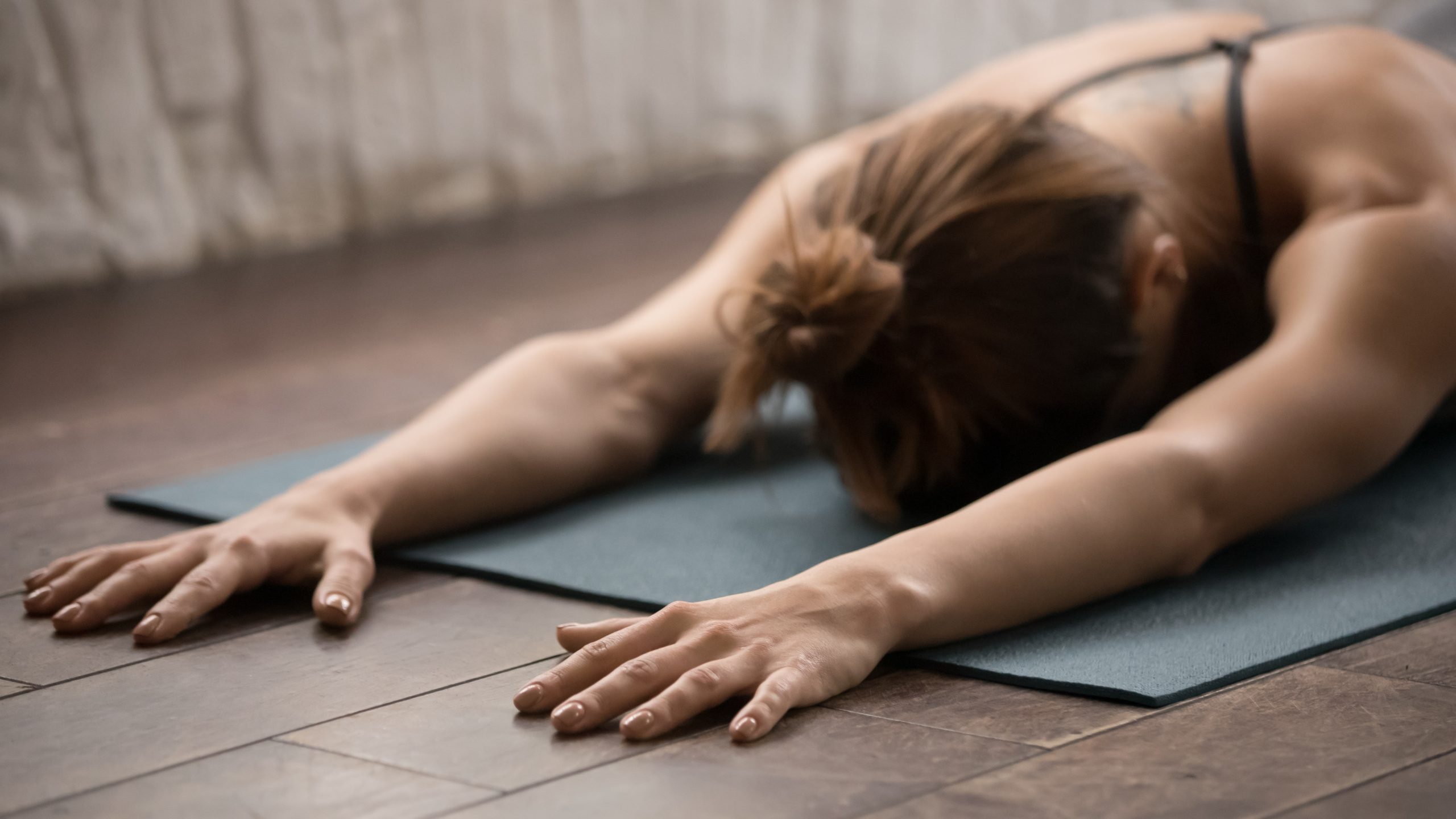 Attractive woman practicing yoga, relaxing after training, lying face down