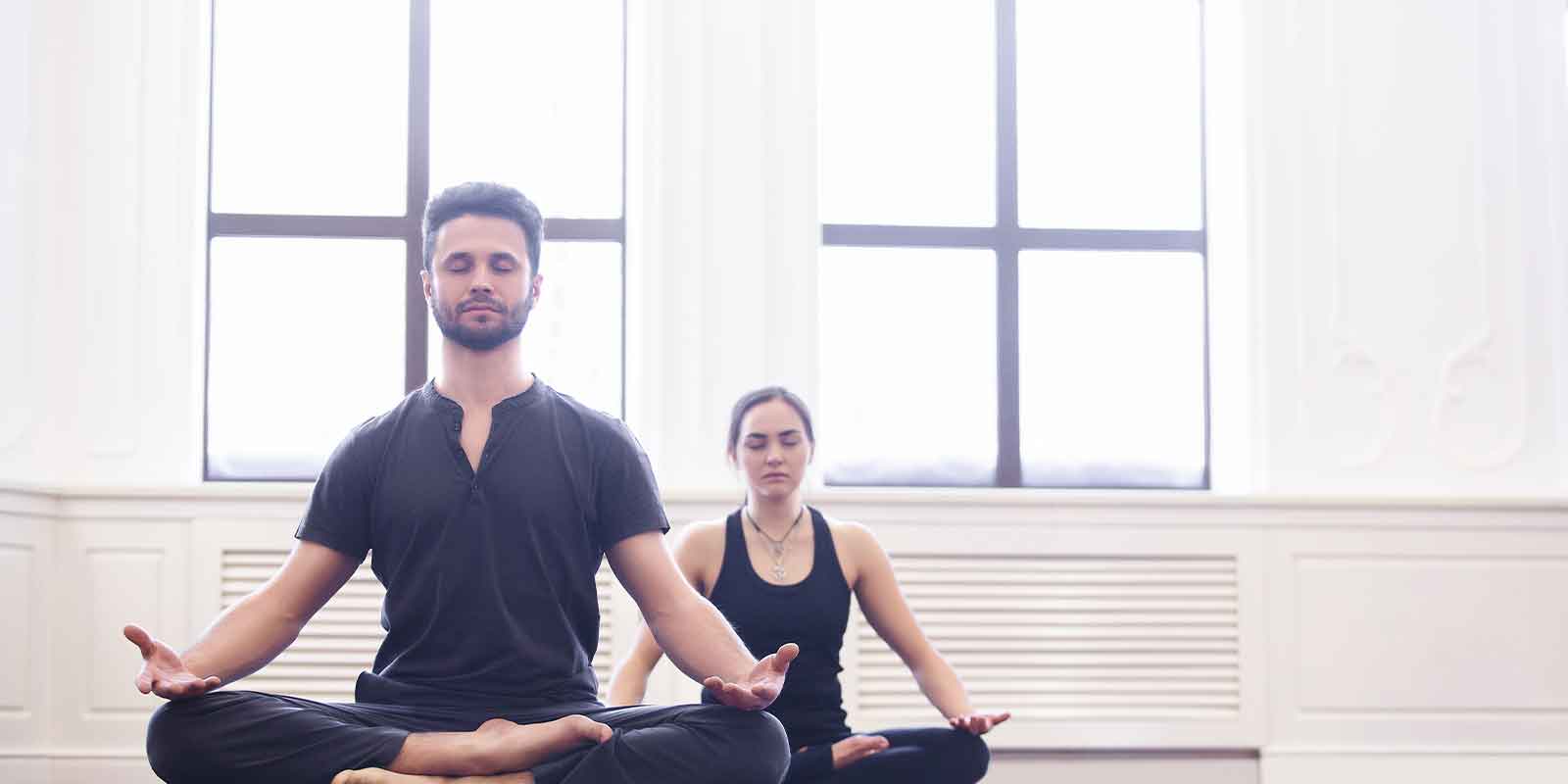 man and woman doing yoga