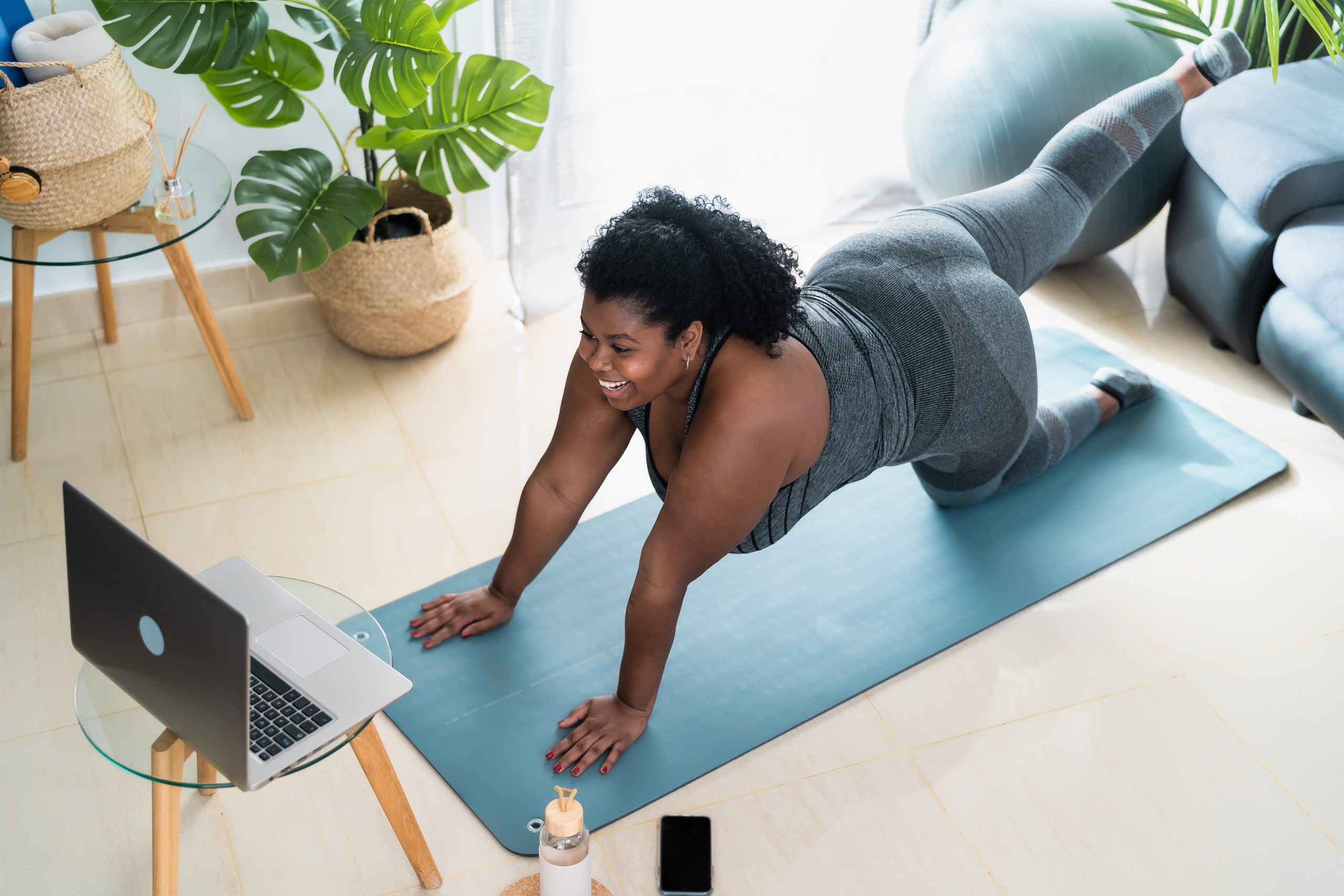 A Person Practicing Yoga Online with Their Laptop