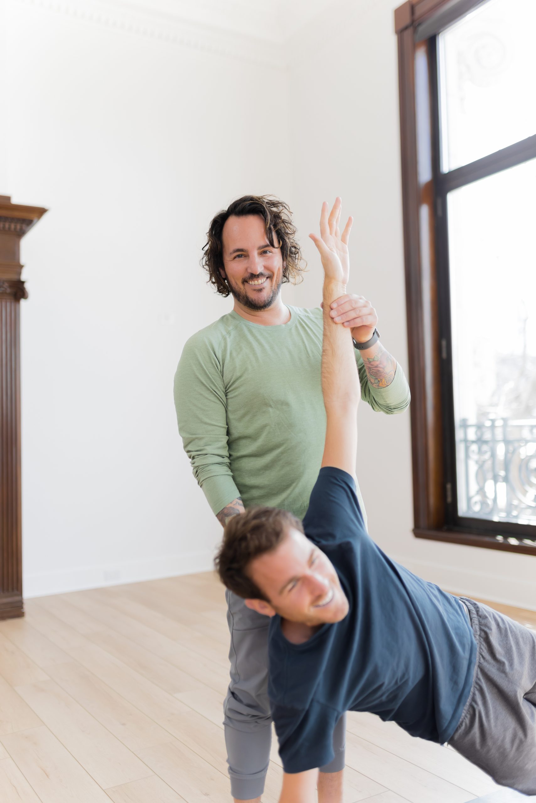 Patrick Franco aligning a yoga student