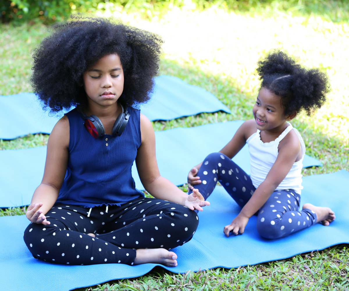 Kids doing yoga outside on mats
