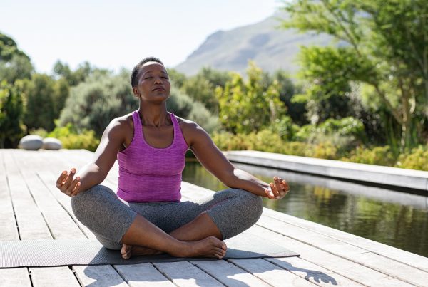 Woman in lotus, breathing outdoors