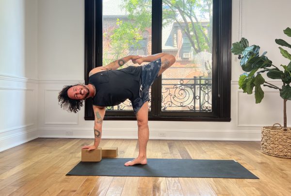 Man in half moon bow pose using one block for the arm reaching to the floor