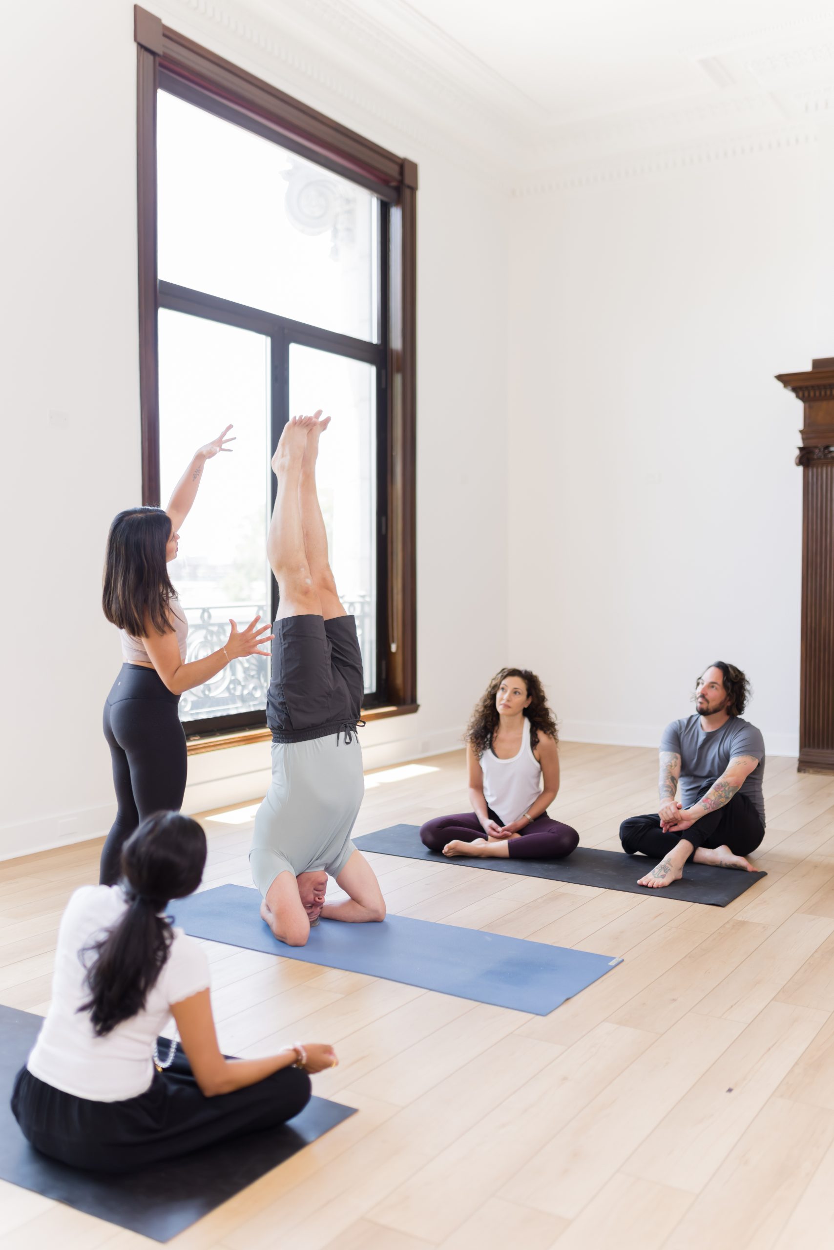 Yoga teacher leading a handstand class