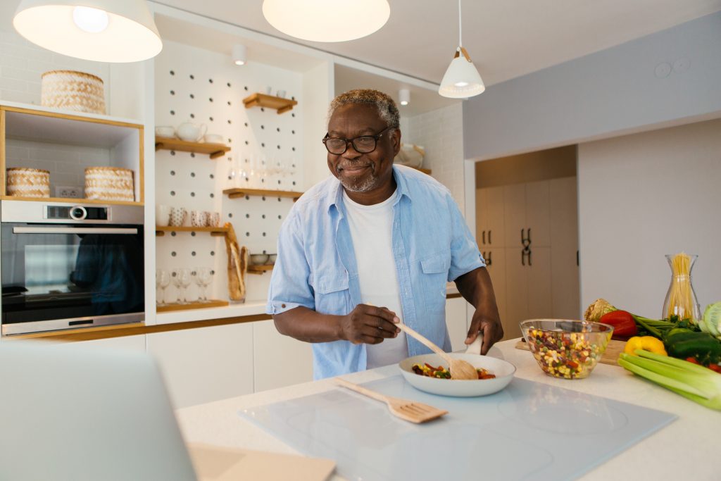 Seorang pria kulit hitam menyiapkan makanan di meja dapur