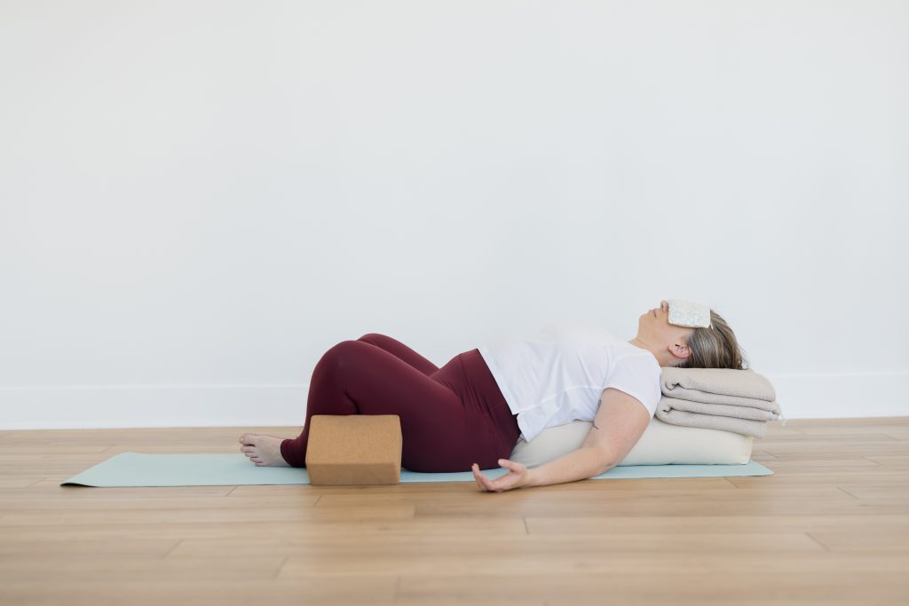 Woman in Supported Supta Baddha Konasana