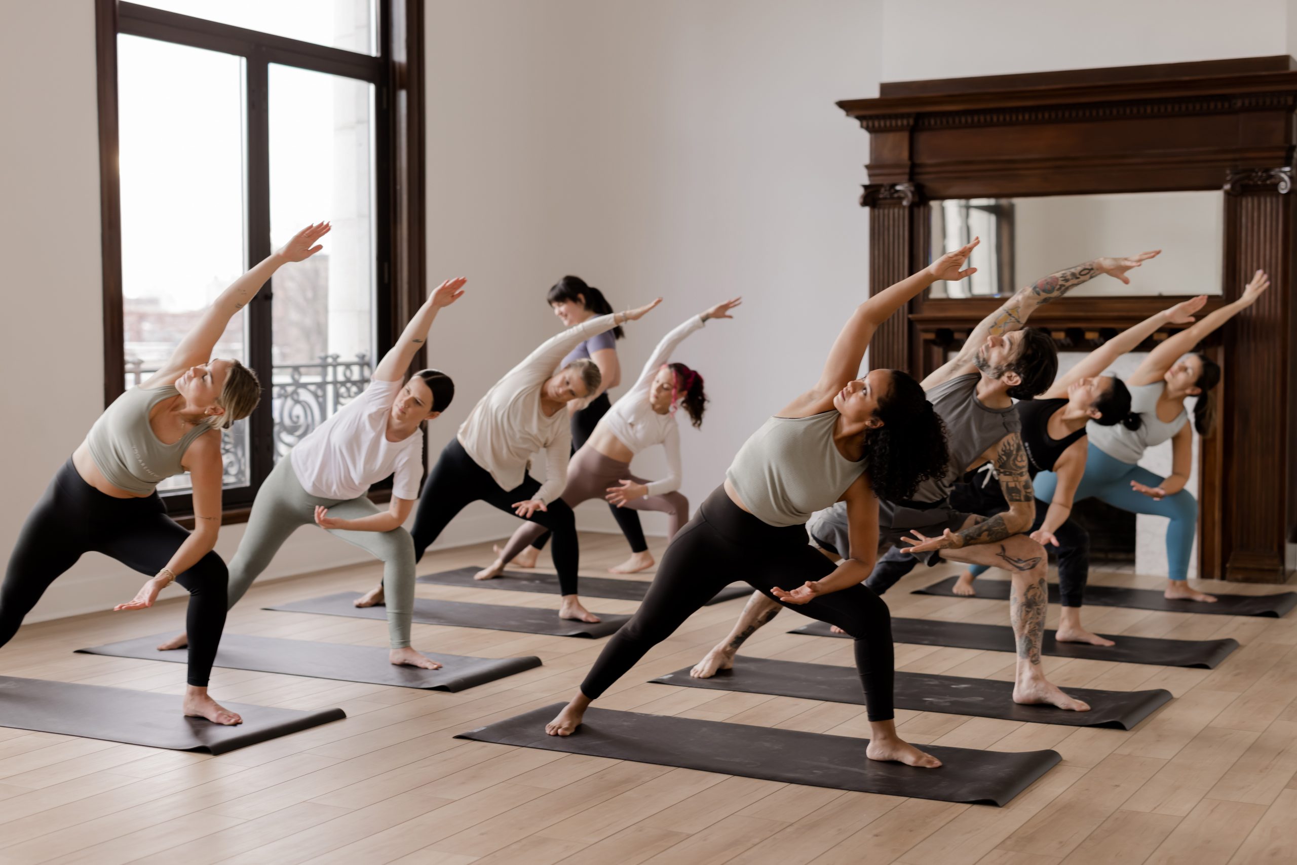 A group of yoga students in extended side angle in a vinyasa yoga class for the vinyasa yoga sequencing course