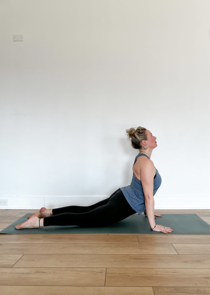 Human in Upward Facing Dog on a green yoga mat