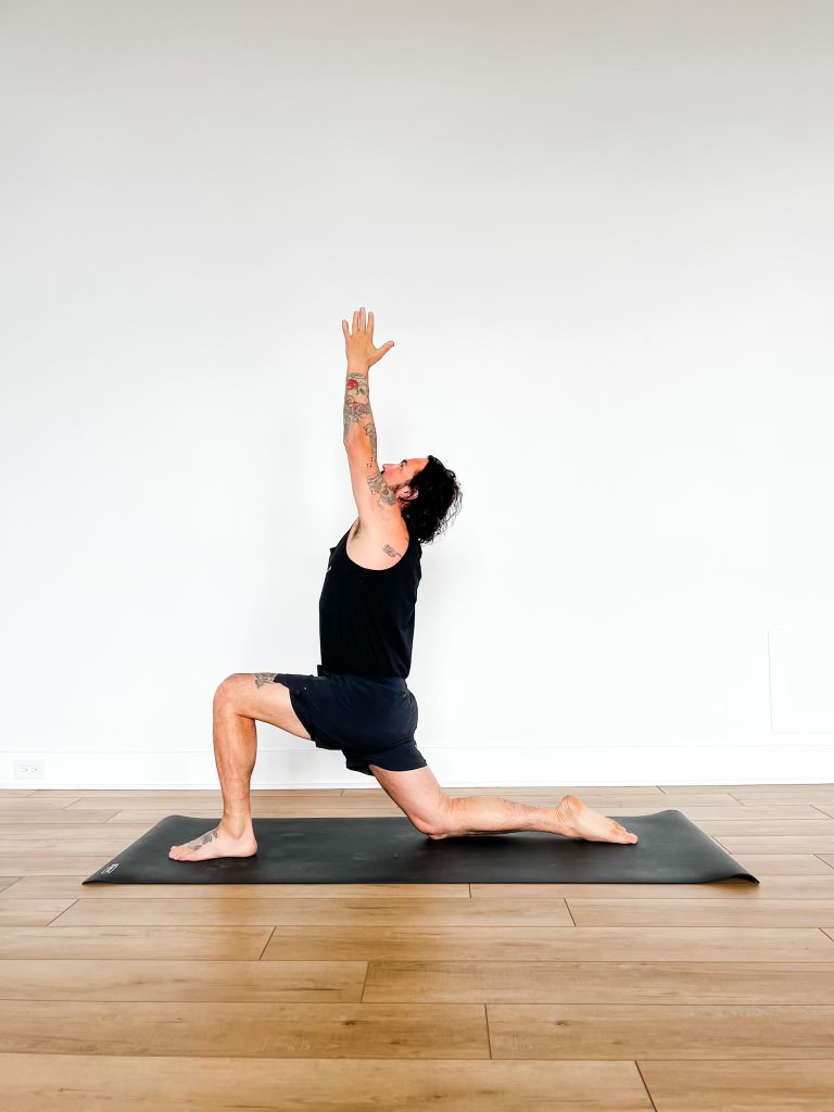 Patrick in crescent lunge pose with arms and hands overhead
