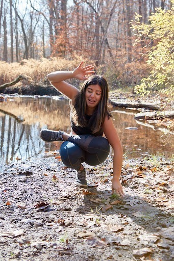 Mel Rodriguez, yoga teacher, falling out of a yoga pose in the woods to show it's okay to make mistakes