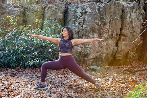 Mel Rodriguez, yoga teacher, in Warrior II pose in the woods