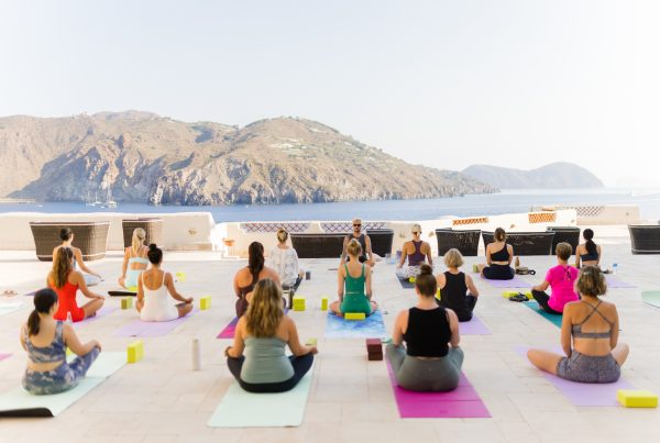 Sicily YogaRenew Retreat crew in Sukhasana, facing a volcano