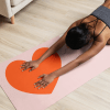 Bridging Gaps yoga mat with yogi in child's pose with their palms over the heart on the yoga mat