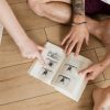 Patrick and Mélie's hands opening Light on Yoga to the page where BKS is in full Salabhasana with his feet up overhead