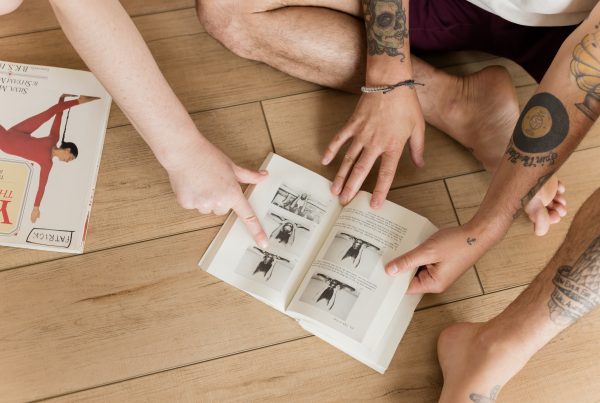Patrick and Mélie's hands opening Light on Yoga to the page where BKS is in full Salabhasana with his feet up overhead