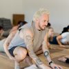 Patrick Franco giving a hands-on assist in cobra pose, touching the back of the calves
