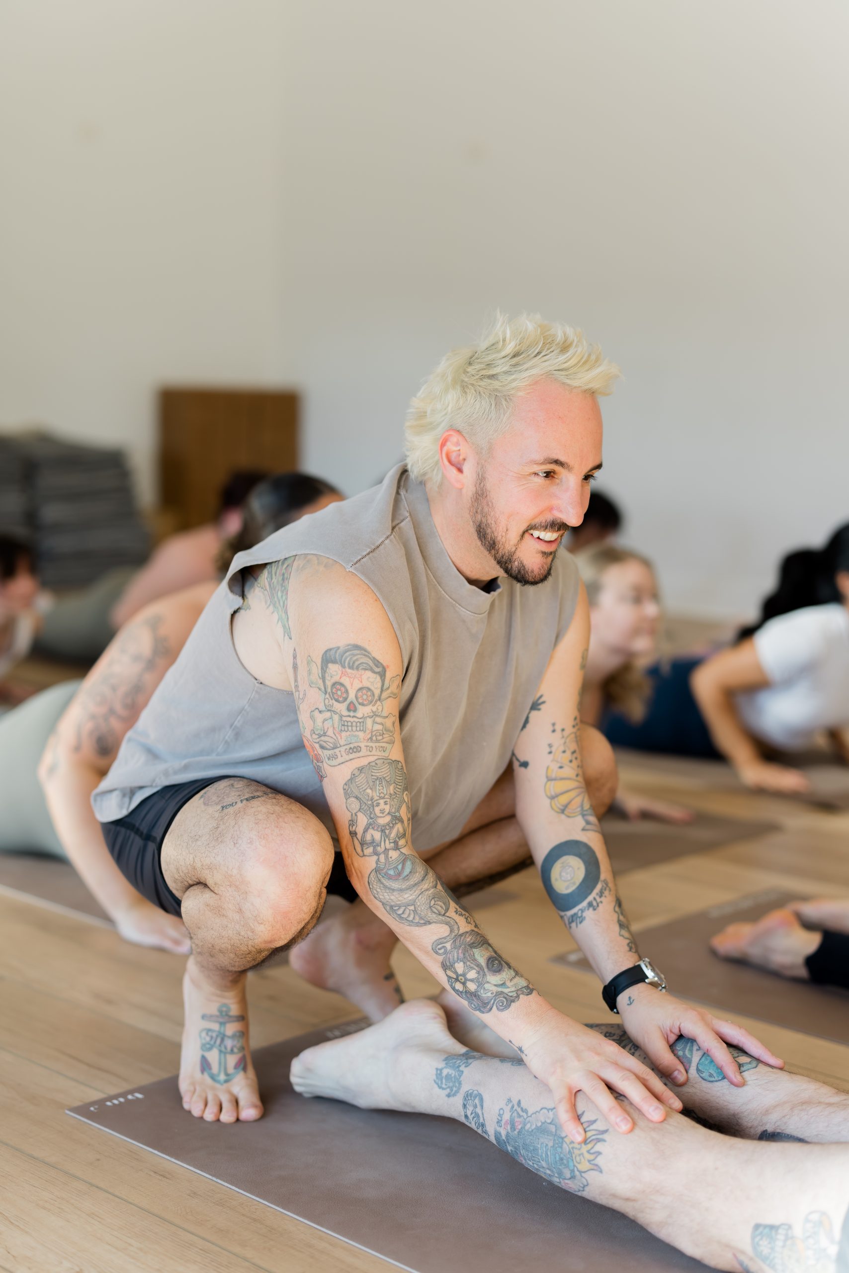 Patrick Franco giving a hands-on assist in cobra pose, touching the back of the calves