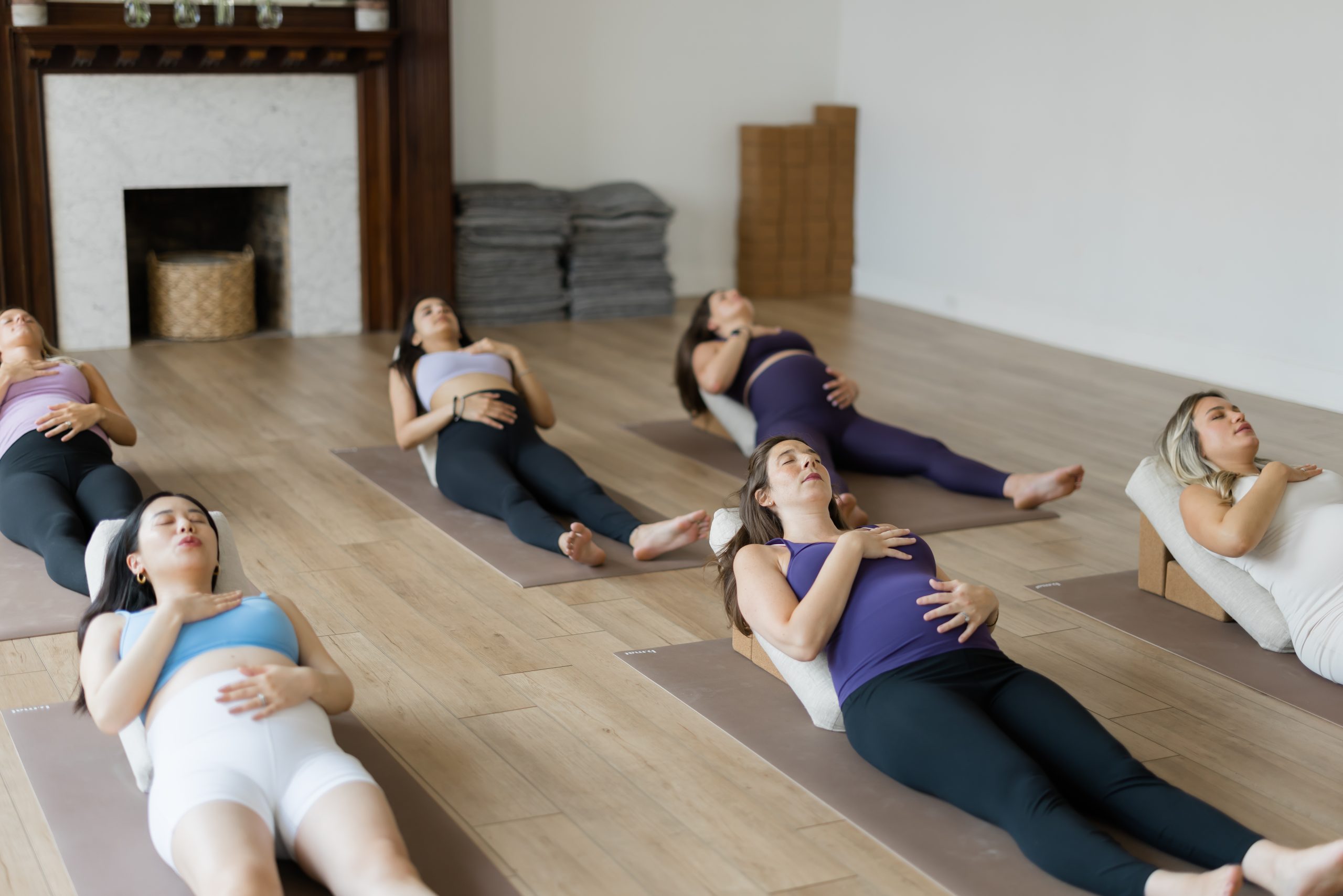 Moms in a prenatal yoga class holding their bellies