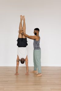 A couple of boy yogis doing a partner handstand