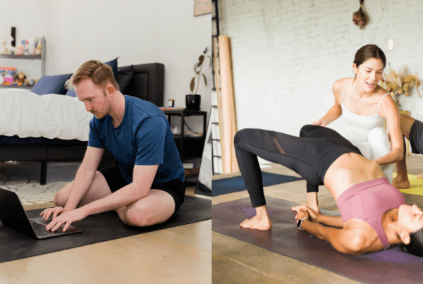 hybrid yoga training image of one student studying online and the other in-person giving a hands-on assist in bridge pose