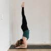 Kate Lombardo in a forearm stand on a black yoga mat the YogaRenew Studio Headquarters in Hoboken, NJ