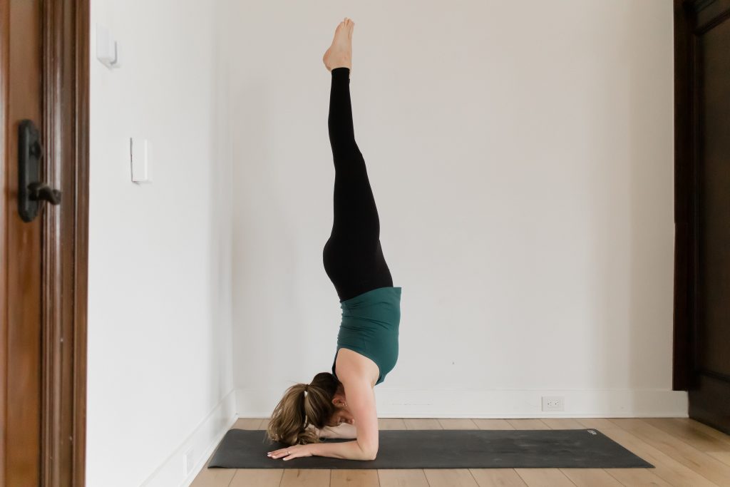 Kate Lombardo in a forearm stand on a black yoga mat the YogaRenew Studio Headquarters in Hoboken, NJ