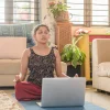 A woman taking our Breathwork & Pranayama Online Course, closing her eyes and breathing to study the anatomy of the breath and benefits of breathwork.