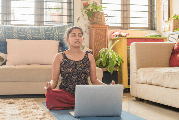 A woman taking our Breathwork & Pranayama Online Course, closing her eyes and breathing to study the anatomy of the breath and benefits of breathwork.